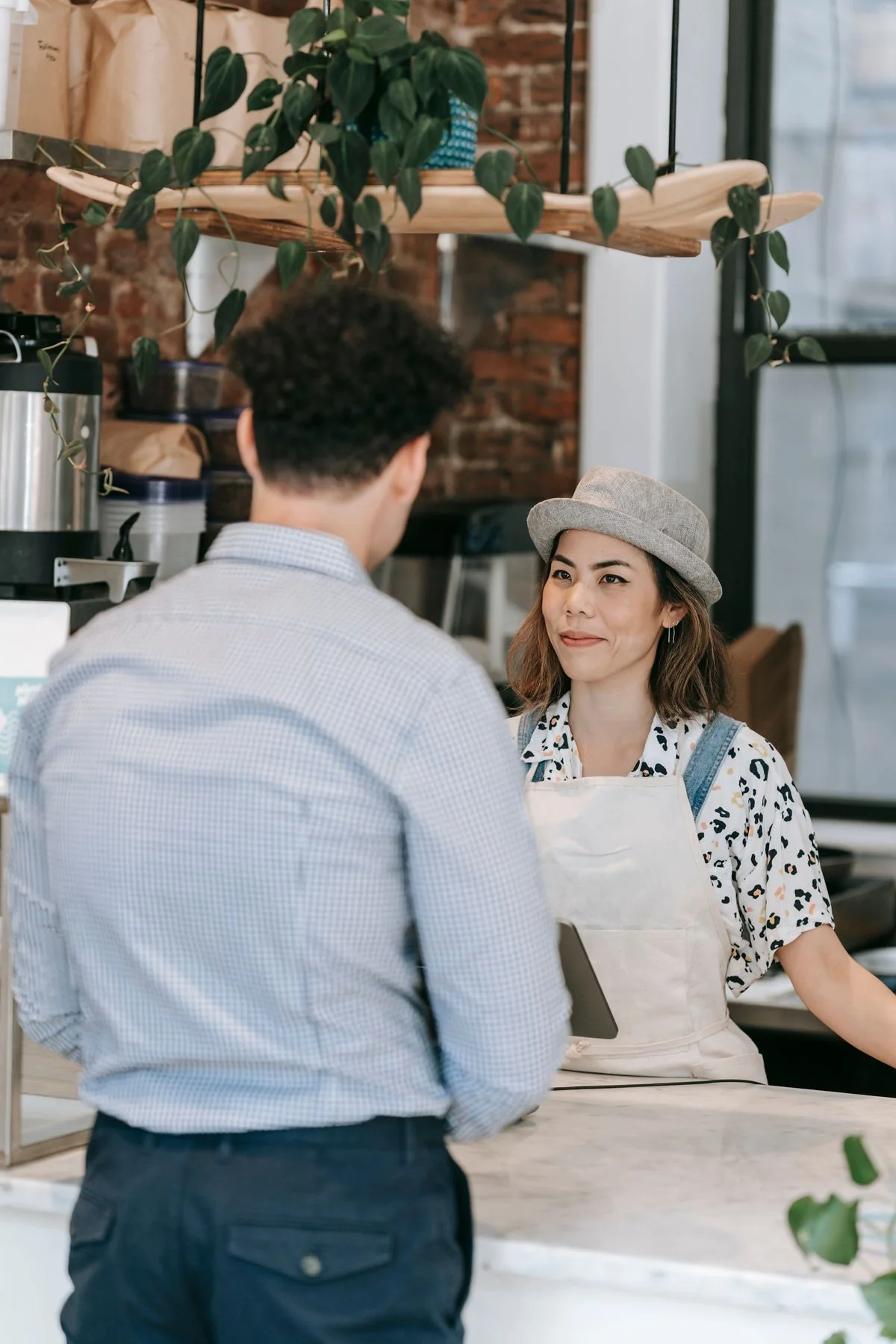 A barista and customer talking across a café counter